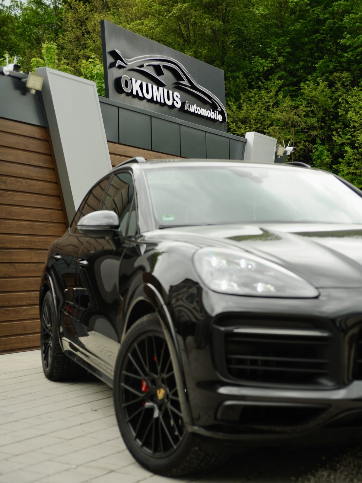 Porsche Cayenne vor dem Autohaus Okumus Automobile in Rohrdorf